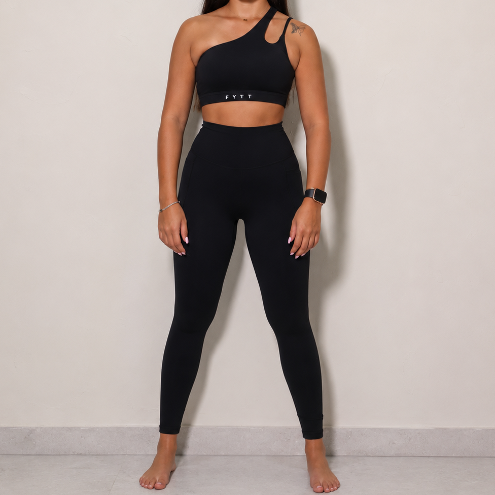black one-shoulder crop top and matching high-waisted leggings. 