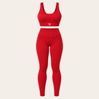 A red two-piece activewear set consisting of a scoop-neck sports bra and high-waisted leggings, shown on a neutral light beige background.