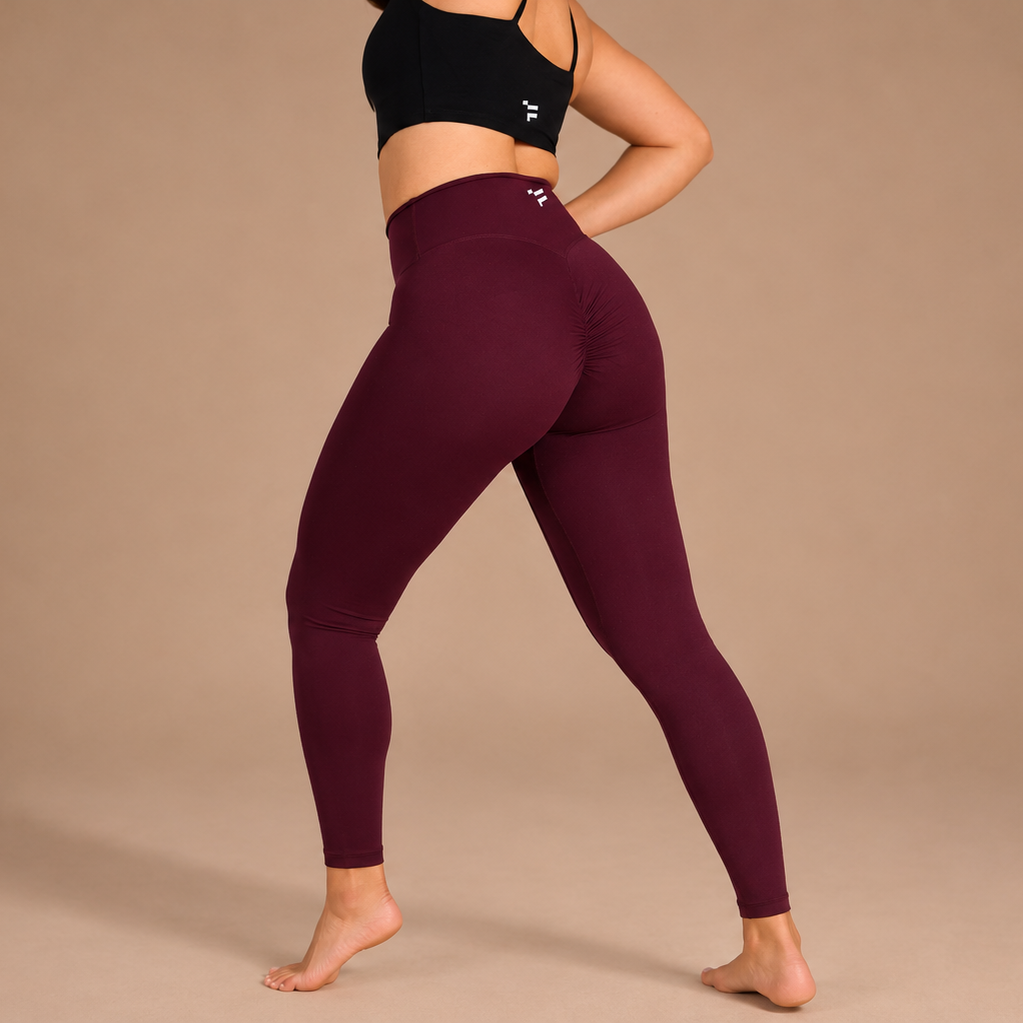  maroon leggings and black sports bra on a beige background